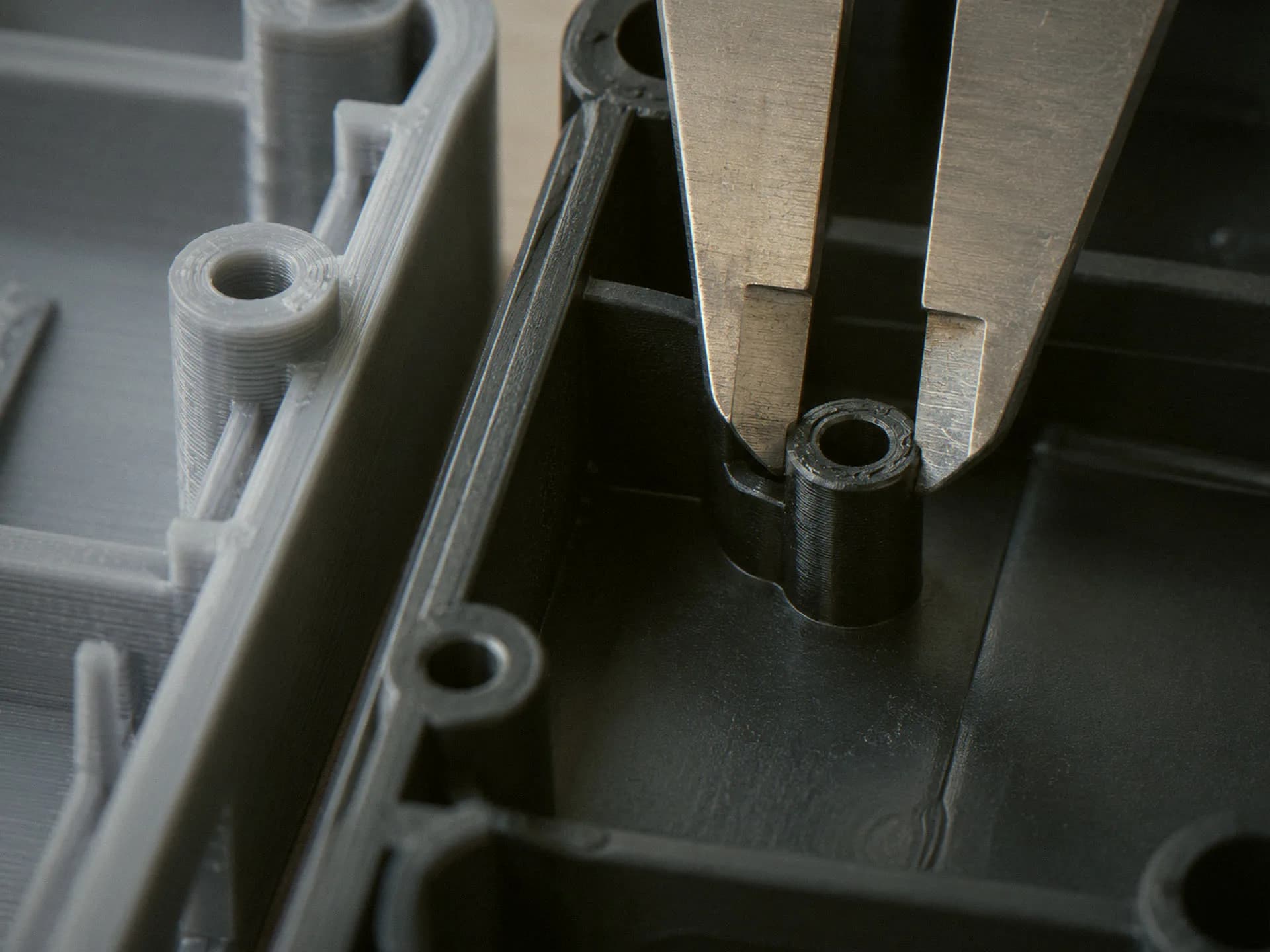 Calipers on a molded housing half beside a printed one