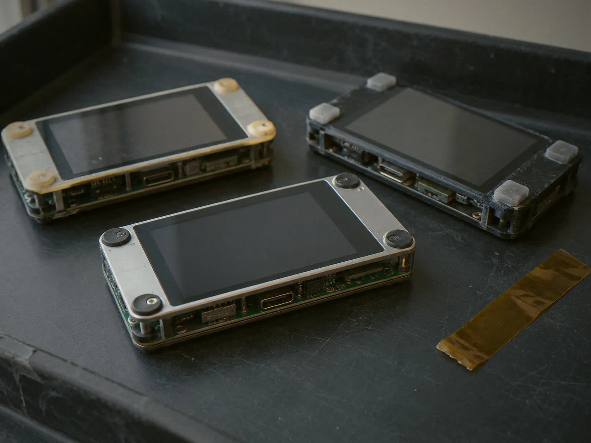 Golden sample prototype beside two earlier revisions on an ESD tray