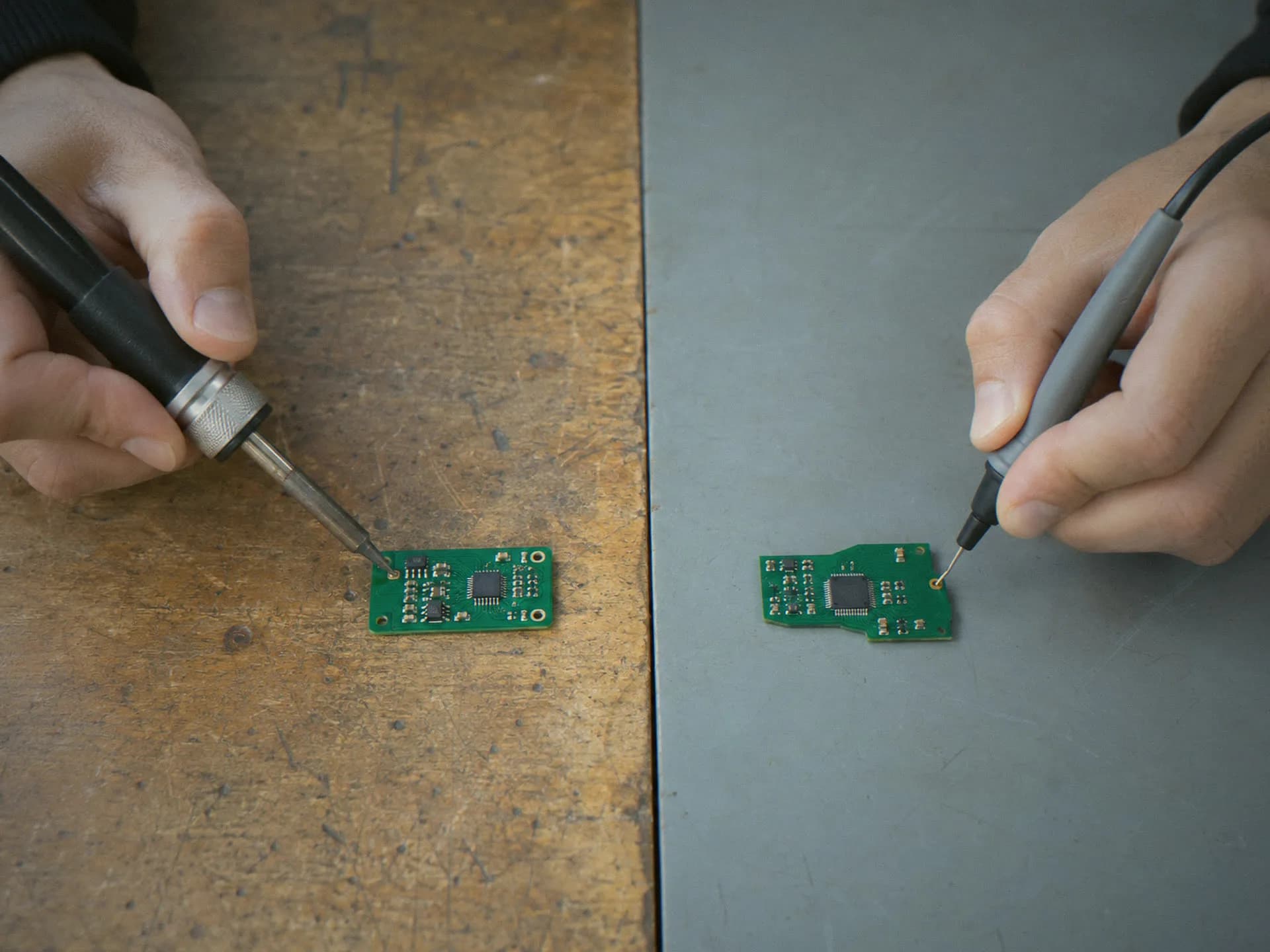 Hands soldering and probing a prototype at two engineering benches