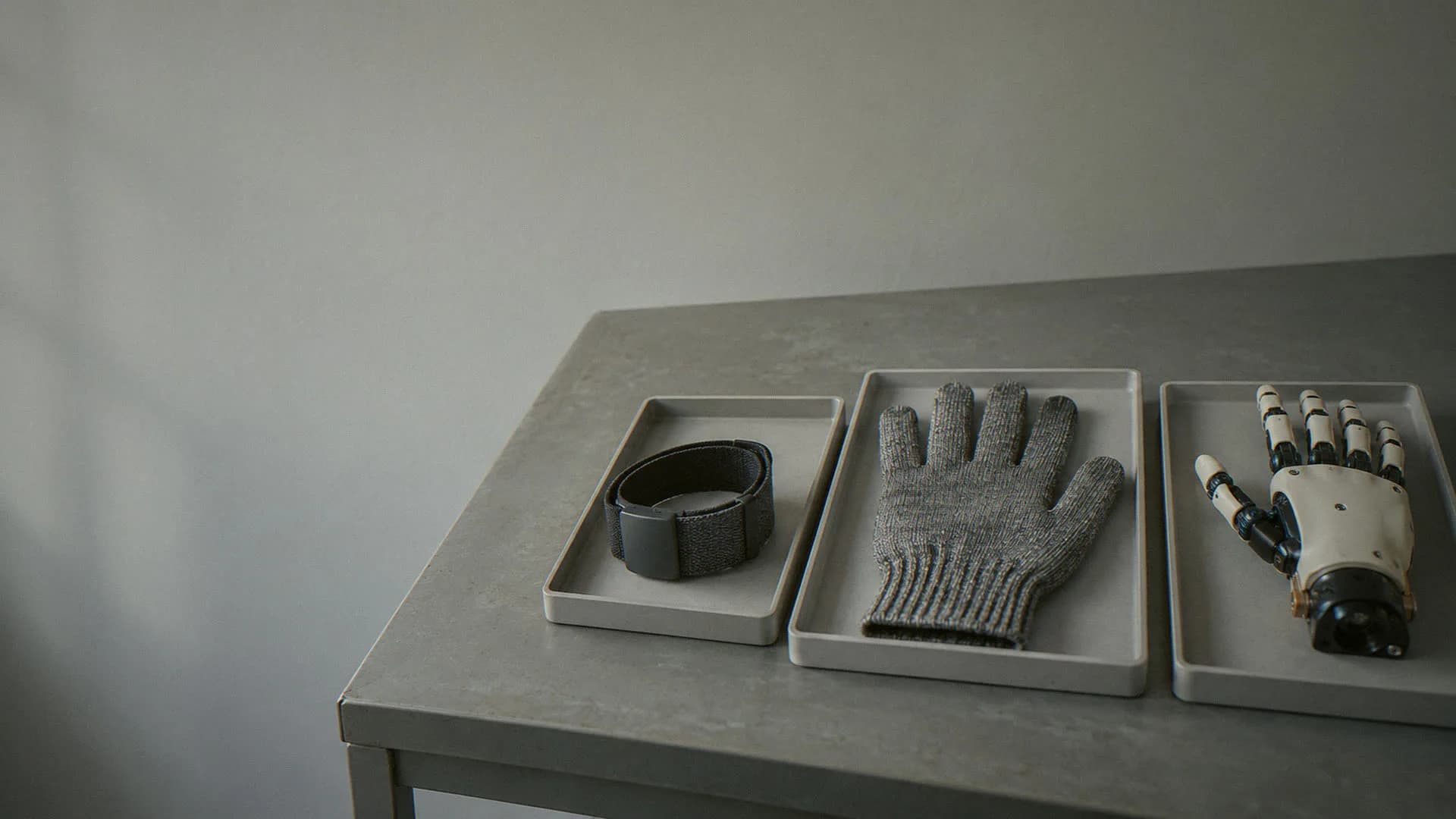 Wearable, glove and robot-hand prototypes on a bench
