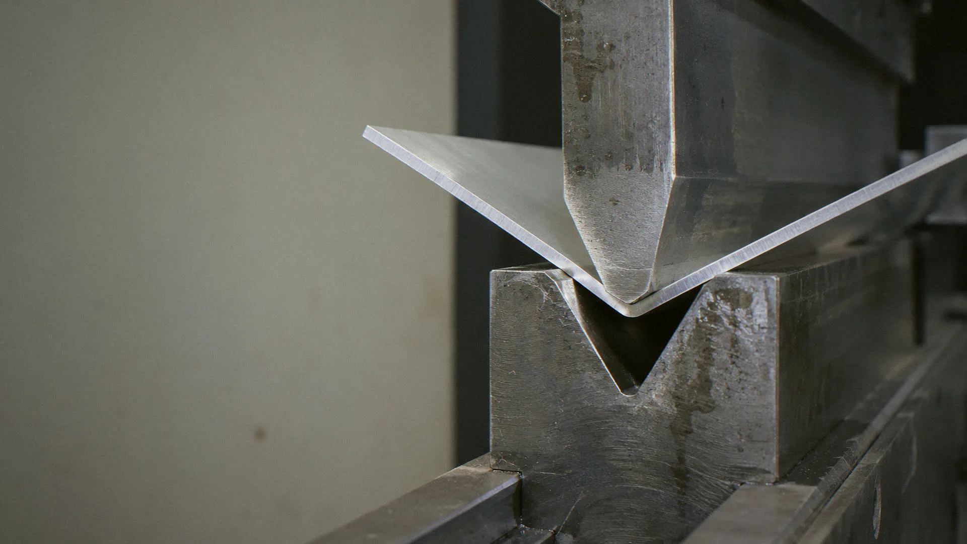 Press brake forming an aluminum enclosure panel