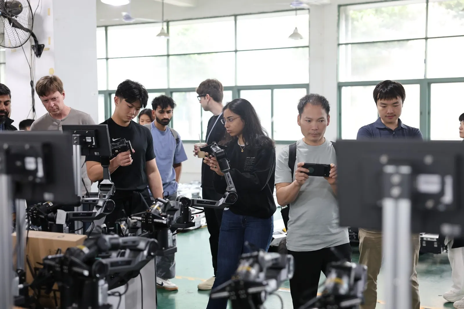 Founders looking at robot arms during a Shenzhen robotics company visit